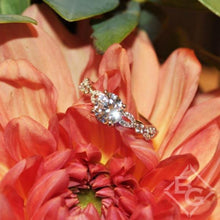 Load image into Gallery viewer, Kirk Kara White Gold &quot;Lori&quot; Vintage Style Twist Diamond Engagement Ring Angled Front View with Floral Background
